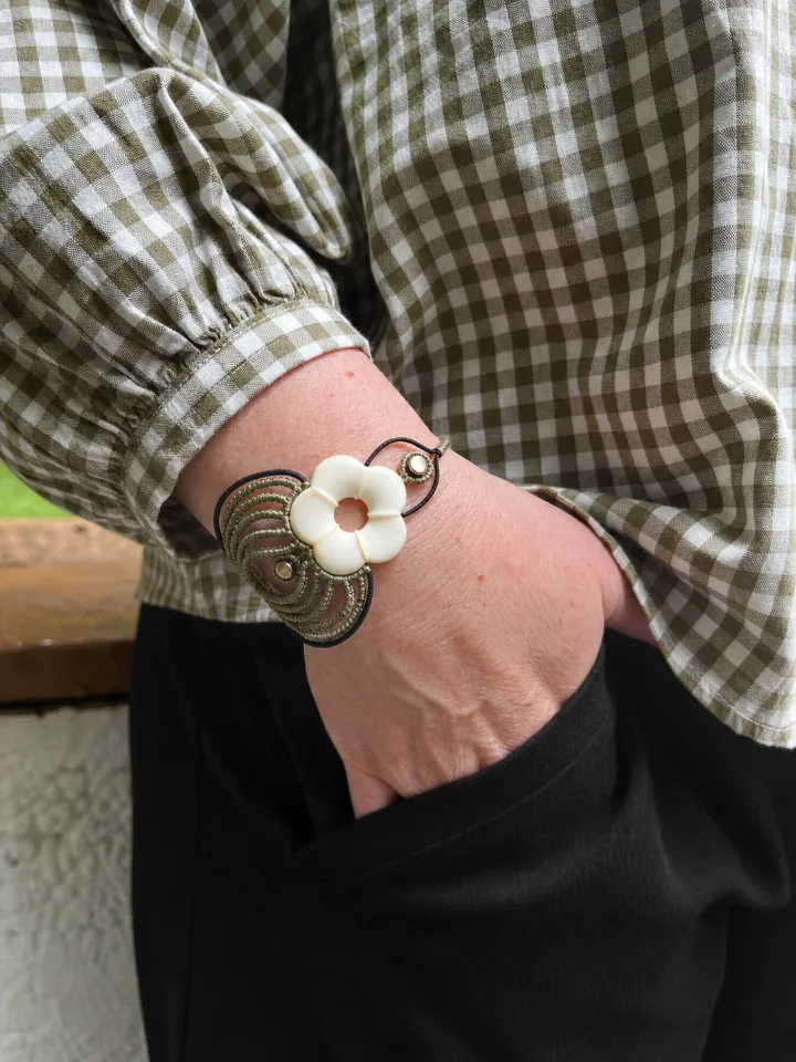 Bracelet fleur en micro-macramé porté au poignet